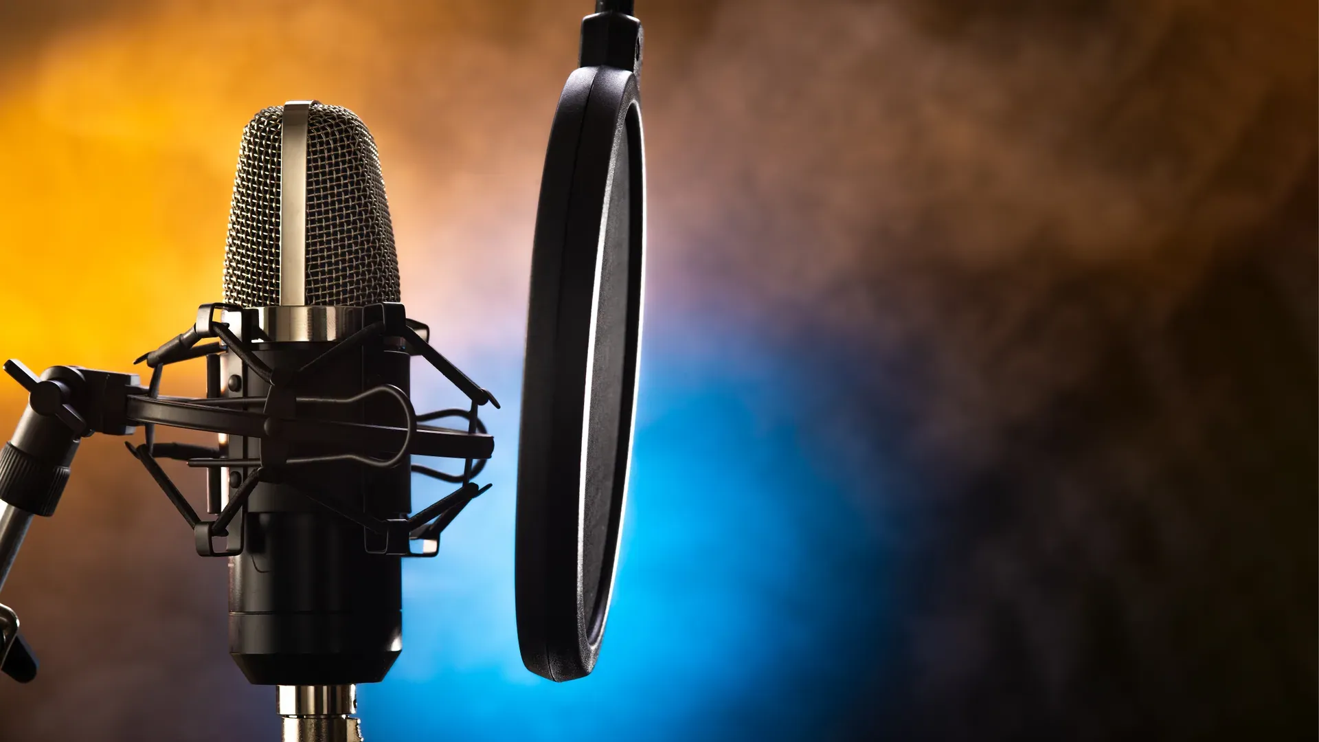 A professional studio condenser microphone with pop filter, dramatic blue and orange studio lighting